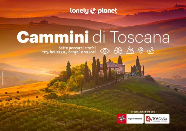 Dolci colline toscane illuminate dal tramonto, con una villa e cipressi. Titolo: "Cammini di Toscana".