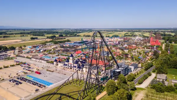 Widok z lotu ptaka na Energylandię, park rozrywki z licznymi atrakcjami, w tym roller coasterami i wodnym światem. Park zajmuje znaczną powierzchnię, odpowiadającą wielu hektarom.