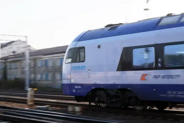 Pociąg PKP Intercity Stadler ED160-007a mija budynek w ruchu. Może to być podróż z Chełma do Krakowa.
