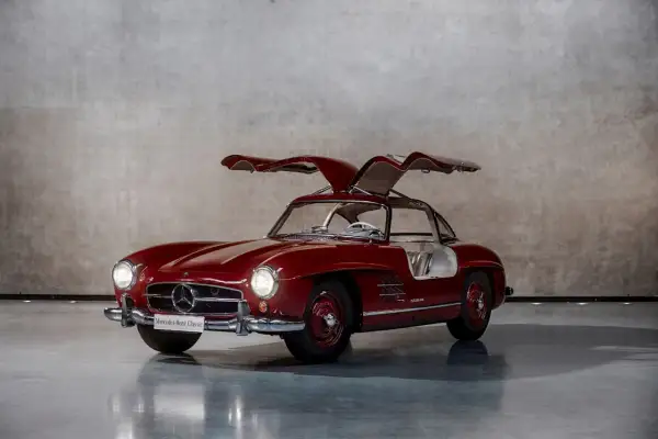 Czerwony Mercedes Gullwing z otwartymi drzwiami, ikona motoryzacji, prezentuje swoje klasyczne linie.