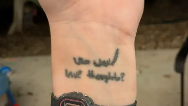 Tatuaz na opalonej skorze z napisem "Who would have thought?".