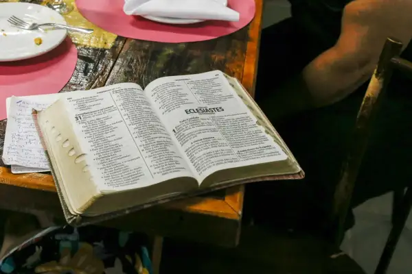 Co Biblia mówi o spowiedzi? Otwarta Biblia na stole, obok talerz i notatki.