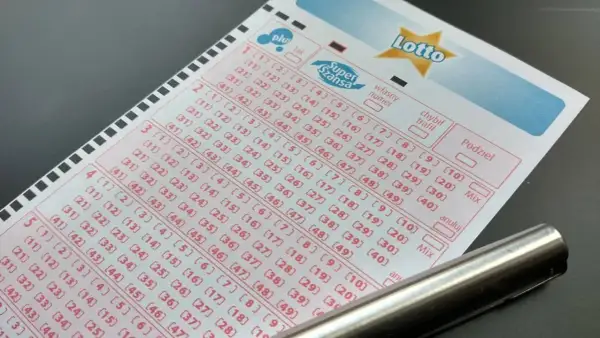 Kupon loterii promocyjnej Kaskada z zaznaczonymi numerami i długopisem.