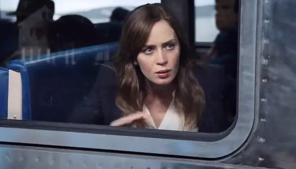 Emily Blunt w filmie, zamyślona, patrzy przez okno pociągu.