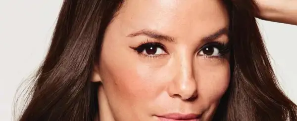 Primer plano de una mujer con pelo fosco y oscuro, ojos marrones con delineado cat eye y piel con rubor.