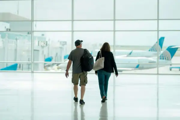 Para idzie przez lotnisko, w tle samoloty United Airlines. Może to ich pierwszy lot czeskimi liniami lotniczymi.