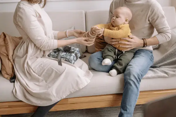Un couple heureux profite de son enfant, un cadeau emballé à côté.