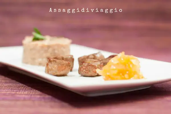 Delizioso fegato con cipolle caramellate, servito con un contorno di risotto.