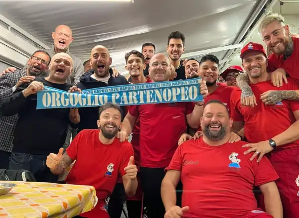 Un gruppo di tifosi esulta con una sciarpa "Orgoglio Partenopeo" e magliette con scritto "Nennella Napoli".