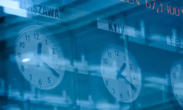 Zegary pokazujące czas w Warszawie i Kijowie, a nad nimi kursy akcji.
