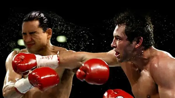 Mario Lopez in a boxing match, caught mid-punch as sweat flies.