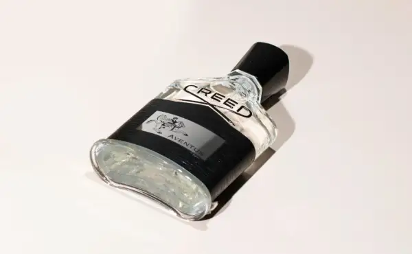 Elegancka butelka perfum Aventus Creed z czarną opaską i wizerunkiem jeźdźca.