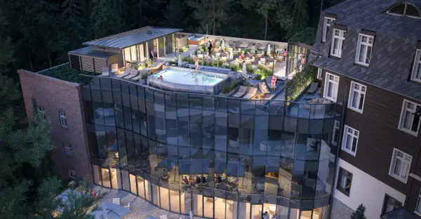Nowoczesny taras z basenem i leżakami przy hotelu Sanssouci Karpacz. Goście relaksują się w otoczeniu zieleni.