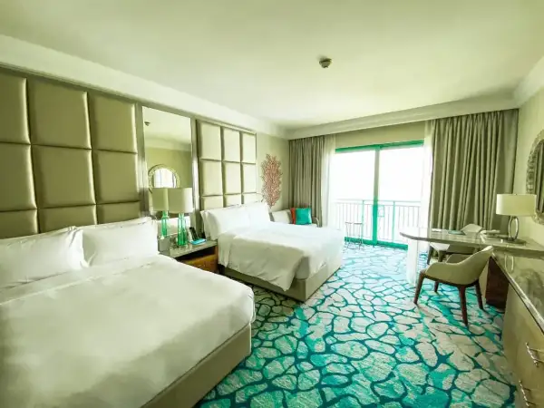 Pokój hotelowy z dwoma łóżkami i dywanem w kolorze mokrej wody.