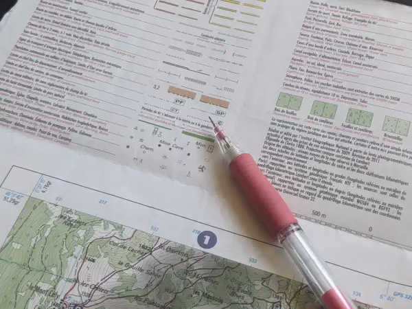 Légende carte IGN : symboles pour bois, mines, grottes, et informations sur les altitudes et les coordonnées.