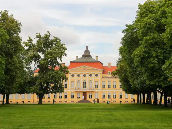 Pałac w Kórniku, jedna z atrakcji wokół Poznania, otoczony zielenią.