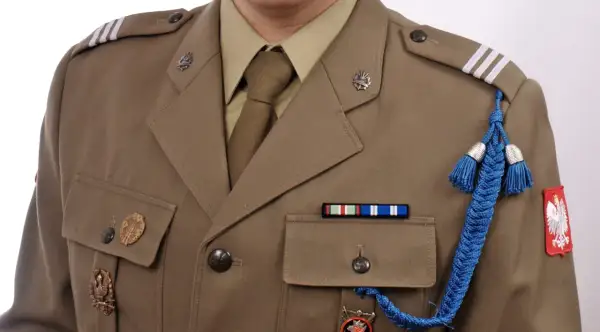 Wojskowa kurtka z odznaczeniami i niebieskim sznurem. Idealne zdjęcie do tapety wojsko.