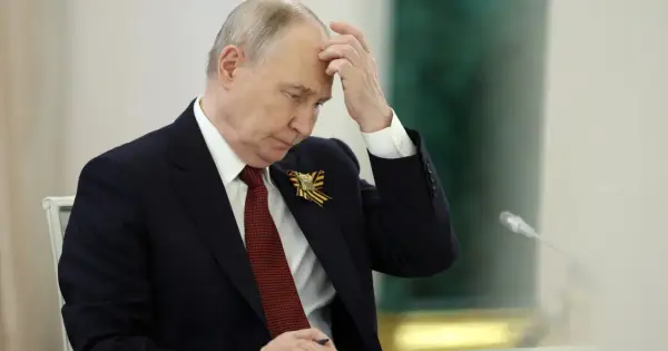 Putin w zamyśleniu, z ręką na czole. Wiek i doświadczenie malują się na jego twarzy.