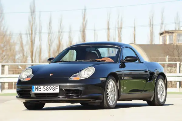 Czarny Porsche Boxster 986 z beżowym wnętrzem, gotowy na wiosenne przejażdżki.