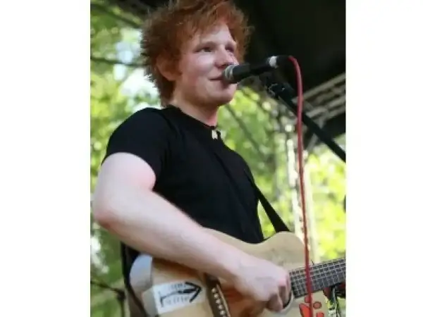Ed Sheeran gra na gitarze, śpiewając do mikrofonu. Czy Ed Sheeran ma dzieci? Tak, jest ojcem dwójki.
