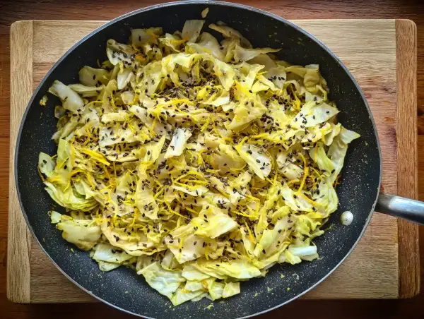 Stekt spetskål med citronskal och svarta sesamfrön i en stekpanna. Enkel och god rätt att grilla spetskål.
