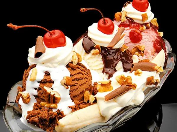 En klassisk banana split med tre kulor glass, banan, grädde, chokladsås, nötter och körsbär. Ett perfekt banana split recept för en varm dag.