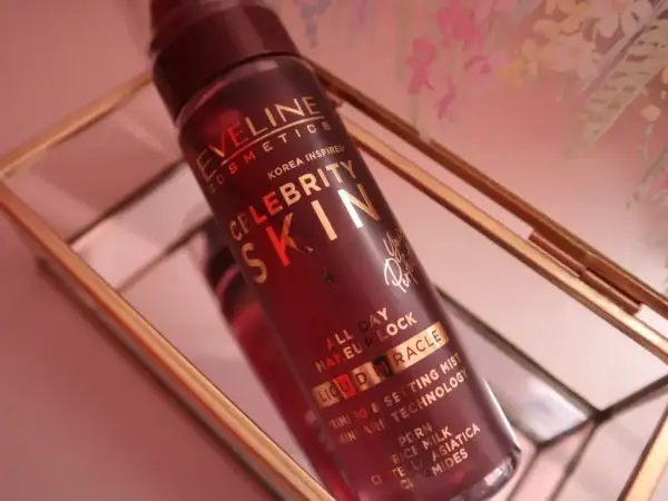 Butelka mgiełki Eveline Celebrity Skin w złotym stojaku.