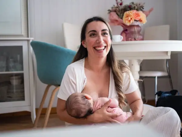 Szczęśliwa mama karmi piersią dziecko, pokazując jedną z wielu zalet karmienia piersią.