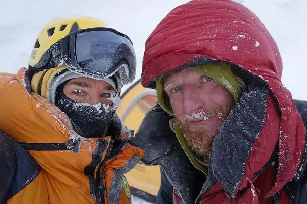 Tomasz Mackiewicz und ein Bergsteigerkollege, bedeckt mit Schnee, blicken in die Kamera.