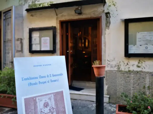 Un cartello annuncia "L'antichissima Chiesa di S. Gennariello (Piccola Pompei al Vomero)" davanti a un ingresso antico.