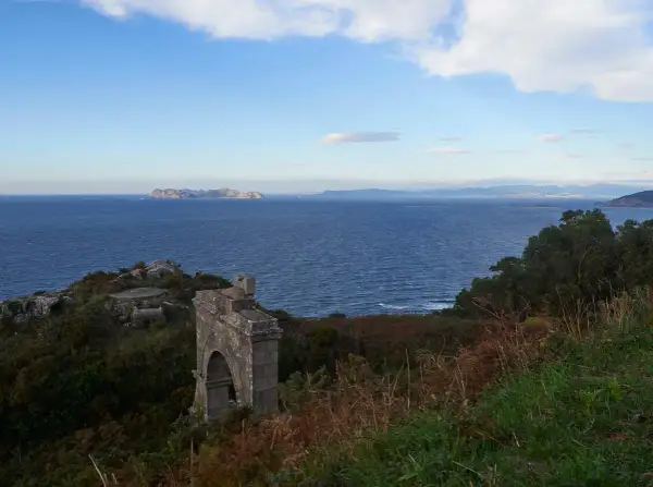 Ruinas de un antiguo faro silleiro, con el mar azul y las islas Cíes al fondo.