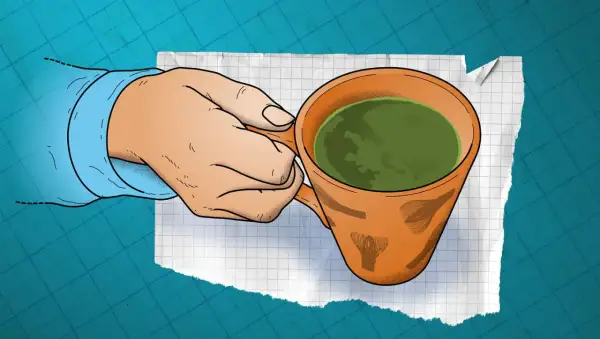 En hand håller en kopp grönt te. Finns det koffein i te? Ja, det gör det, men mindre än i kaffe.