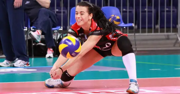 Paulina Bałdyga w akcji na boisku siatkarskim, z determinacją przyjmuje piłkę.