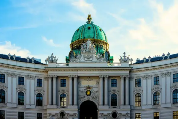 Prunkvolle Kuppel des Hofburg-Palastes in Wien, ein absolutes Wien must see. Majestätische Architektur unter blauem Himmel.