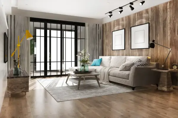 Soggiorno moderno con divano beige, tavolino in legno, tappeto grigio e parete effetto legno. Un esempio di come arredare casa con poco, puntando su pochi elementi ben scelti.