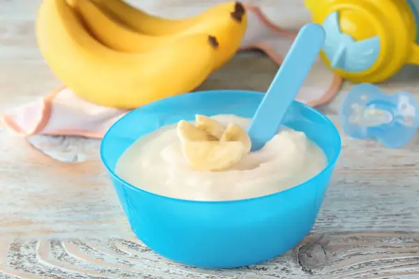 Semolino alla banana in ciotola blu, pronto per essere gustato. Ecco come si fa il semolino per i più piccoli!