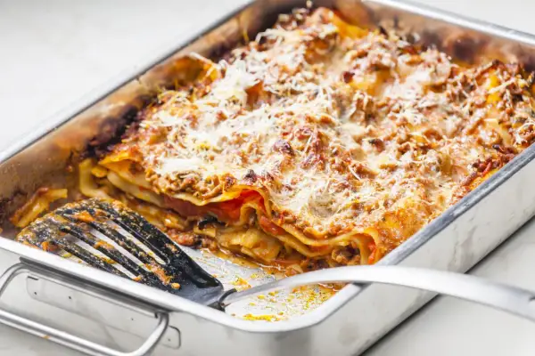 Lasagnes généreuses dans un plat, prêtes à servir. Une quantité parfaite pour régaler 12 personnes.