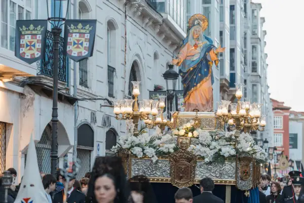 Procesión de Semana Santa. La Virgen María, adornada con flores, es llevada en andas. Se pregunta cuándo es la procesión del encuentro.