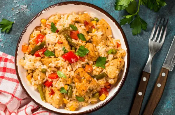 Pyszne risotto z kurczakiem, warzywami i ziołami w misce, gotowe do podania.