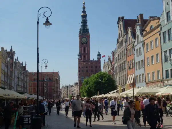 Piękna pogoda w Gdańsku w lipcu. Tłumy spacerują ulicą Długą podziwiając kamienice i Ratusz.