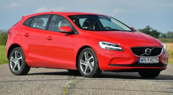 Czerwone Volvo V40 D3 na drodze, z widoczną sylwetką kierowcy.