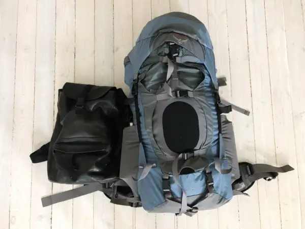 Två ryggsäckar, en stor blå och en mindre svart, redo för en packlista tågluff.