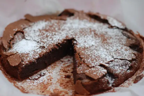 En saftig kladdkaka med pudersocker, perfekt för kladdkakans dag.