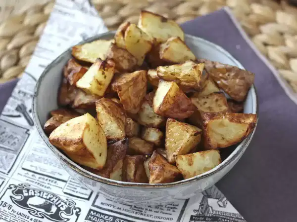 En skål med gyllene, krispiga rostad potatis. Perfekt tillbehör som doftar ljuvligt.
