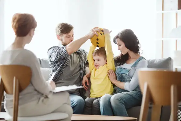Rodzina z dzieckiem na terapii, gdzie omawiane są zaburzenia zachowania ICD10.