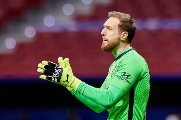 Bramkarz Jan Oblak w zielonej koszulce z rękawicami, gotowy do obrony.