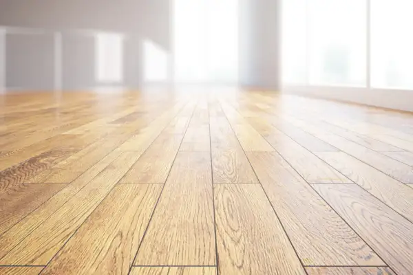 Pavimento in legno massiccio, con venature naturali che riflettono la luce. Un ambiente luminoso e accogliente.
