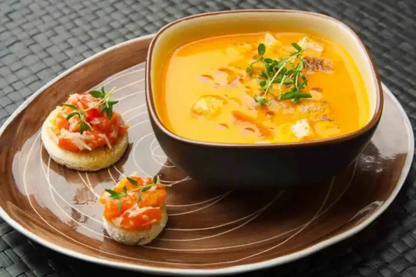 Ein cremiges Gazpacho-Rezept mit Croutons und frischen Kräutern, serviert mit kleinen Bruschettas.