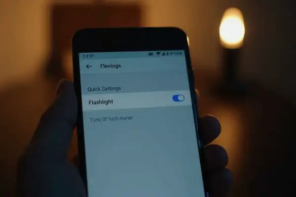 Na ekranie telefonu widać opcję "Flashlight" z włączonym przełącznikiem. Aby wyłączyć latarkę, wystarczy przesunąć suwak.