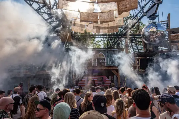 Menschenmenge bei einem Festival in den Woodlands Hildesheim, umgeben von Rauch und Dekorationen.
